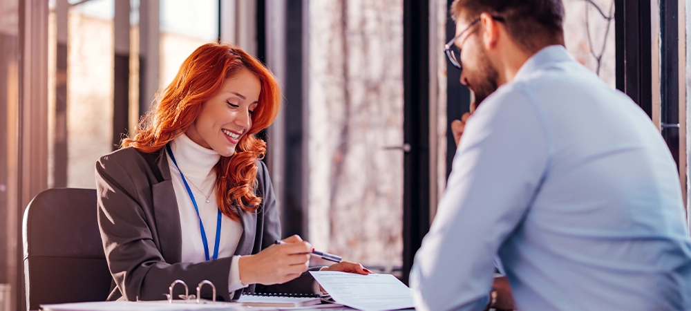 business people man and woman sitting at the table in the office and signing the contract
