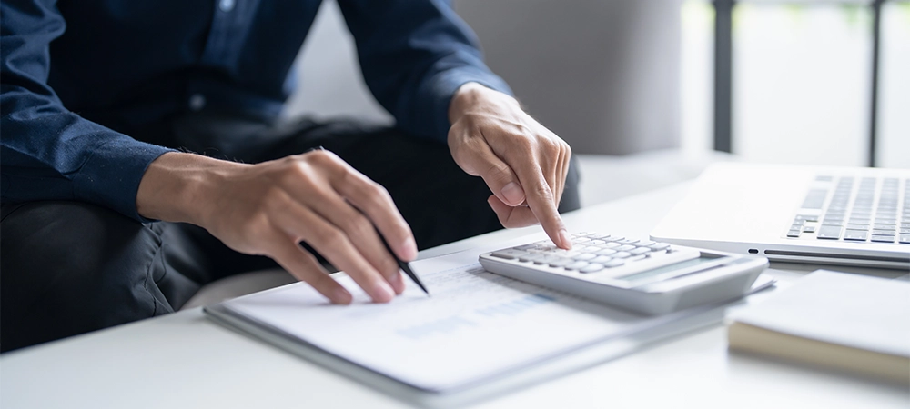 man calculate finances home pay bills taxes on mobile phone and calculator financial at home