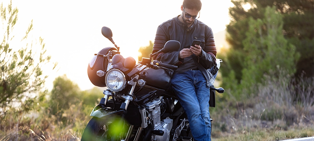 shot of man biker talking on the phone to the insurance of his motorcycle after having suffered a breakdown on the road