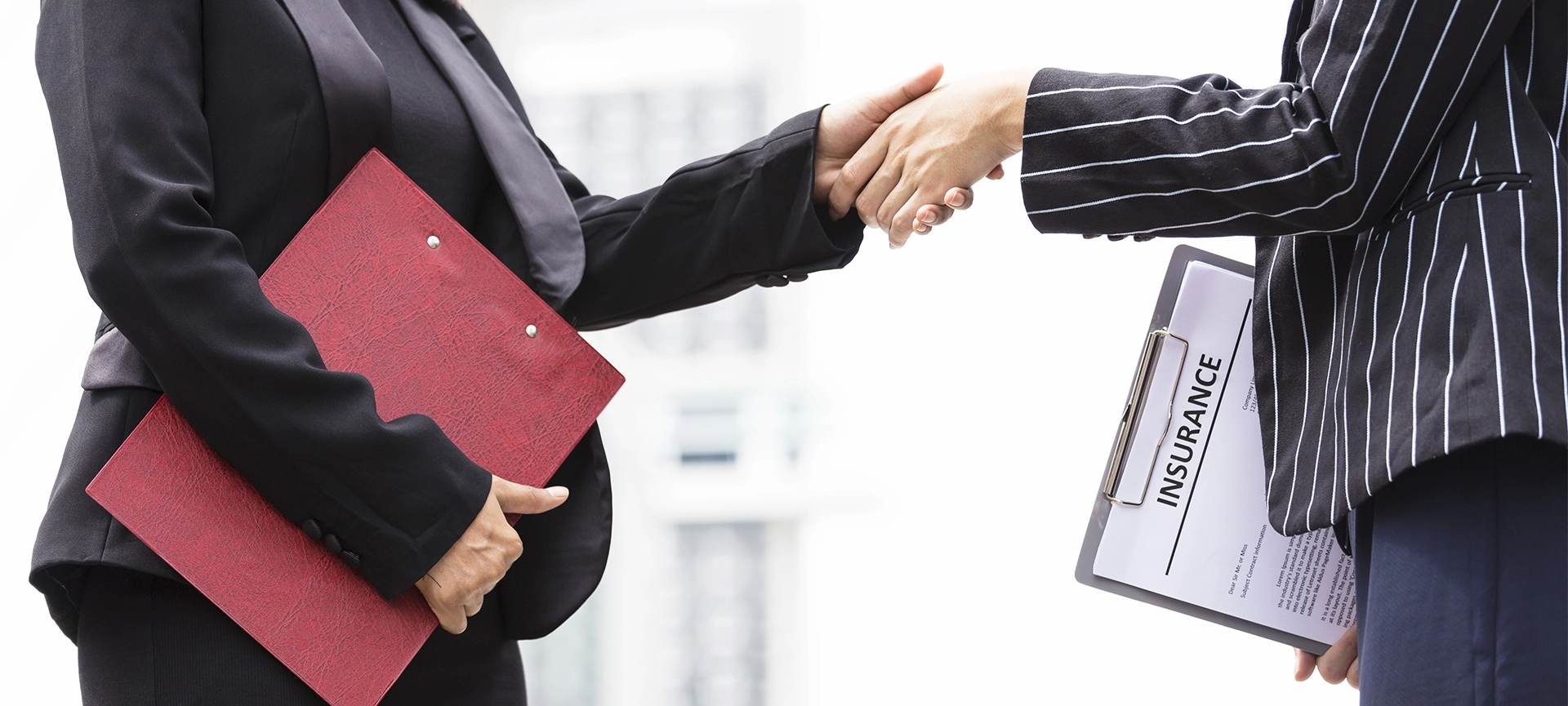 Businesswomen with insurance broker Shaking Hands In the Office