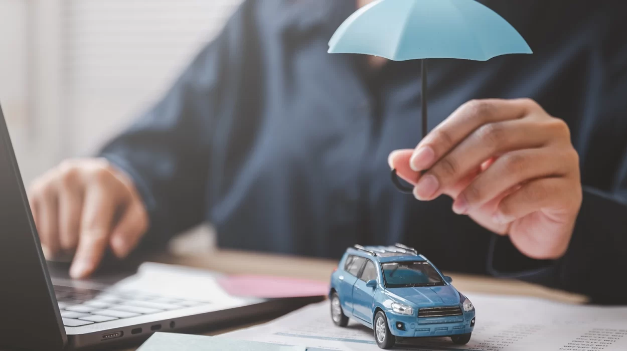 Car insurance protect safe transport. Safety trust. Protection secure assurance. A woman is holding a blue umbrella over a toy car on a desk.