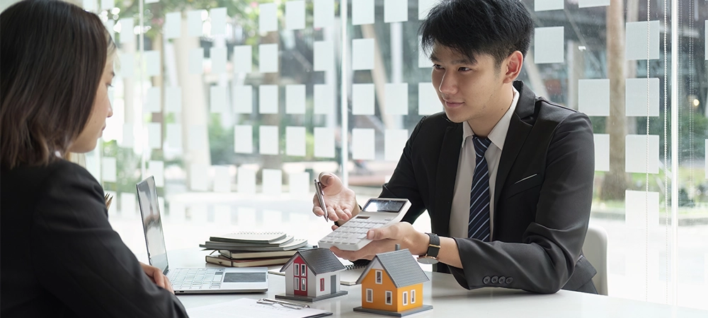 Real estate agents talk to client and offer good interest rates and calculate clients on mortgage financing