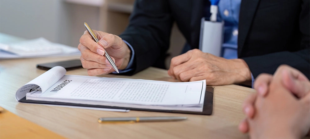 Insurance Consultation. Business professional reviewing policy documents with a client.
