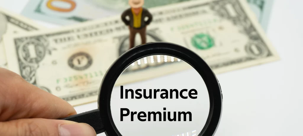 Insurance Premium.Magnifying glass showing the words. Background of banknotes and coins. basic concepts of finance.Business theme. Financial terms.