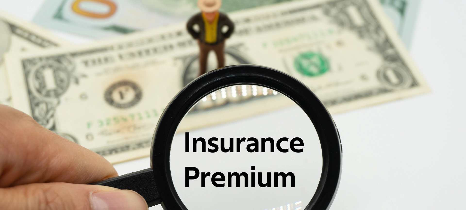 Insurance Premium.Magnifying glass showing the words. Background of banknotes and coins. basic concepts of finance.Business theme. Financial terms.
