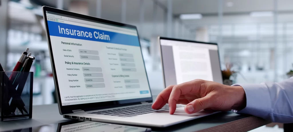 Close-up Of Person Hand Over Insurance Claim Form